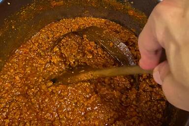 Rühren des langsam köchelnden Ragùs - Stirring the slow cooking ragù