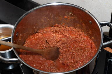 Rühren des langsam köchelnden Ragùs - Stirring the slow cooking ragù