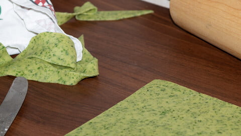 Pasta Verde - ausgerollter grüner Teig auf Arbeitsplatte - rolled out green dough on kitchen counter