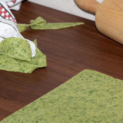 Pasta Verde - ausgerollter grüner Teig auf Arbeitsplatte - rolled out green dough on kitchen counter