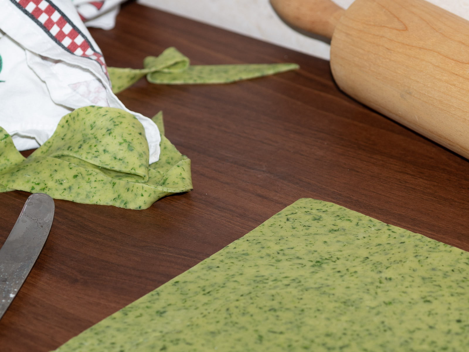 Pasta Verde - ausgerollter grüner Teig auf Arbeitsplatte - rolled out green dough on kitchen counter