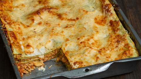 Lasagne verdi alla Bolognese in einer Auflaufform, ein Stück herausgeschnitten - Lasagne verdi alla Bolognese in a baking try, one piece cut out