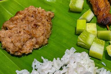 Satay-Sauce mit Reis, Gurken und Hähnchen-Satay - Satay Sauce alongside rice, cucumber and chicken satay