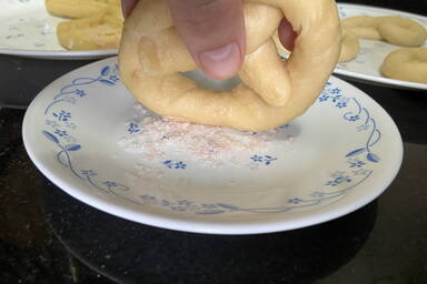 Drücken der Brezel in grobes Salz - Putting the pretzel into coarse salt