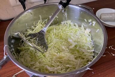 Stampfen des Krauts mit dem Salz in einem großen Topf - Mashing the cabbage together with salt in a large pot