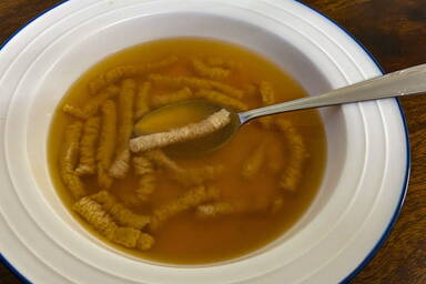 Passattelli romagnola en brodo - in einer Suppenschüssel mit Löffel - in a soup bowl with a spoon