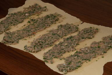 Ausgerollter Teig mit darauf verstrichener Maultaschenfüllung - Rolled out dough with the filling for Maultaschen spread on top