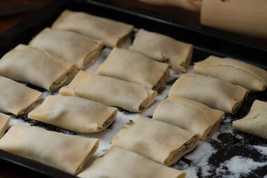 Gefüllte Maultaschen auf einem Blech mit Weizengrieß - Maultaschen on a tray with semolina