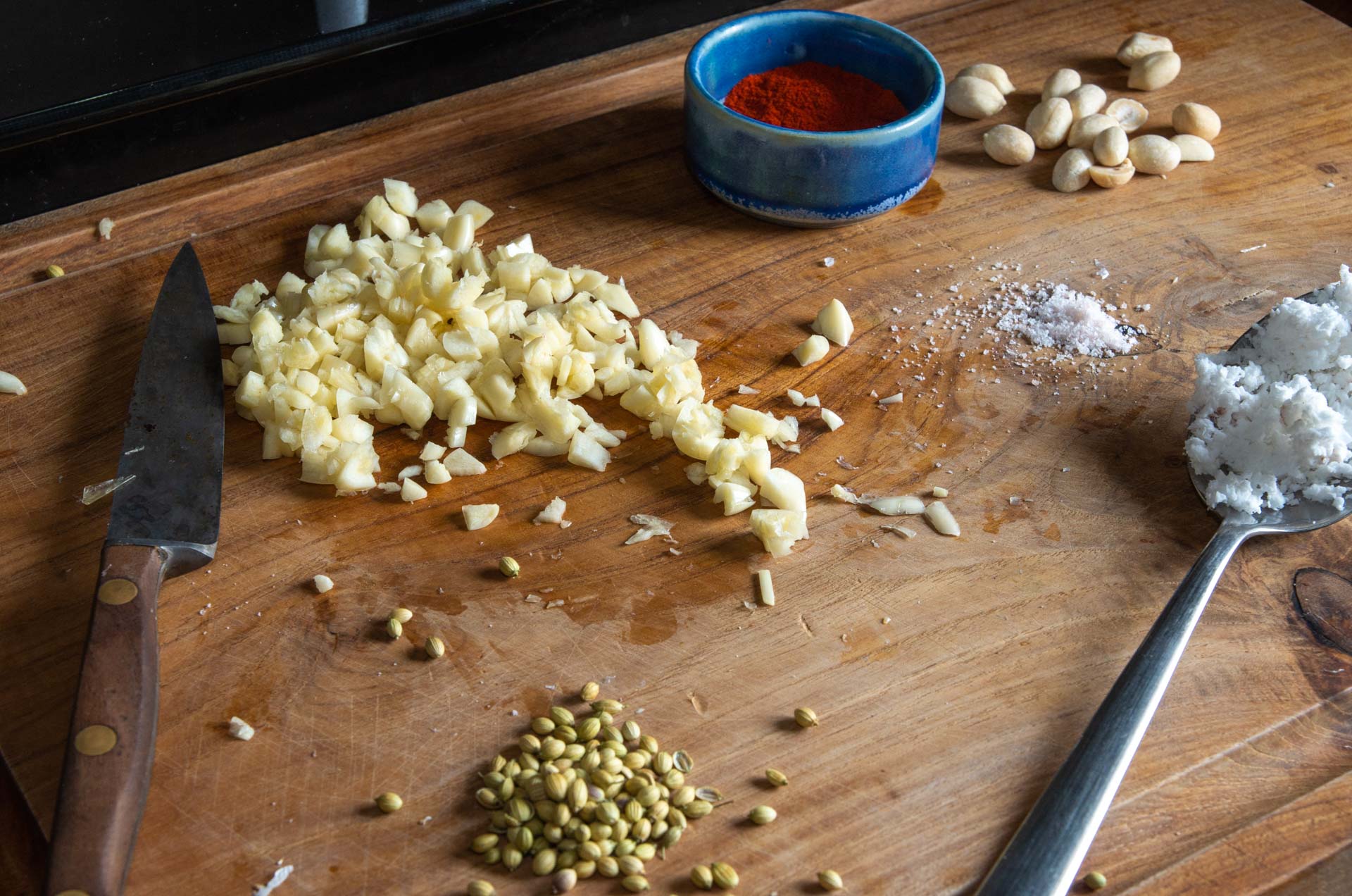 Zutaten für indisches trockenes Knoblauchchutney auf einem Schneidebrett aus Holz - Ingredients for Indian dry garlic chutney on a wooden chopping board