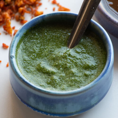 Indisches grünes Chutney in einer kleinen Schale, dahinter süßes Chutney und trockenes Knoblauchchutney - Indian green chutney in a small bowl, in the background sweet chutney and dry garlic chutney