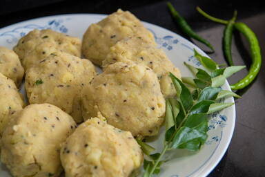 Geformte Kartoffelklöße für Batata Vada bevor der Ausbackteig dazu kommt - Shaped potato dumplings for batata vada before dipping them into the batter