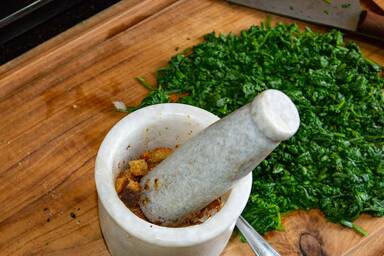 Im Mörser gestoßenes Brot und gehackter, blanchierter Spinat - Bread pounded in a mortar and chopped blanched spinach